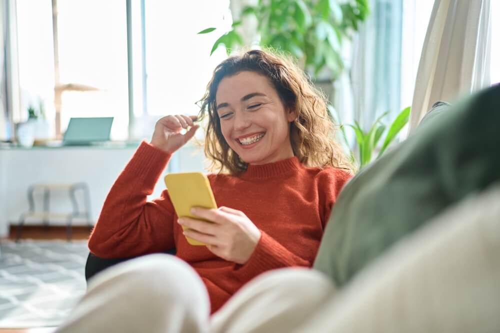 relaxed young woman sitting on couch, How to Find Social Media Accounts by Email Free