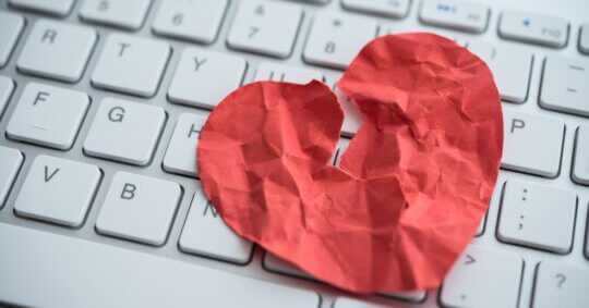broken red heart paper on keyboard