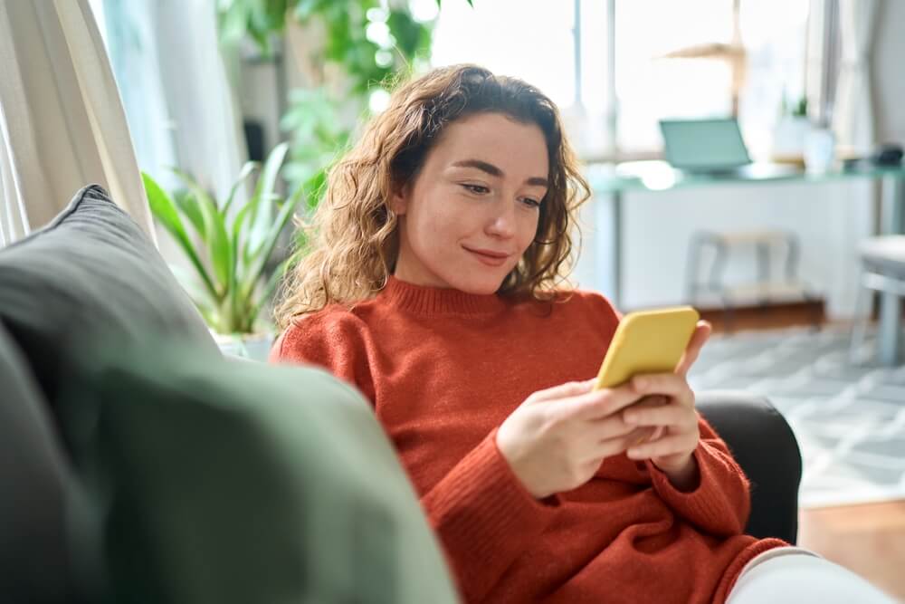 A young woman asking online dating questions on phone