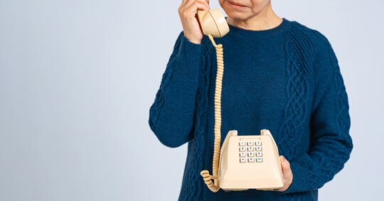 A senior woman dialing phone numbers to never call.
