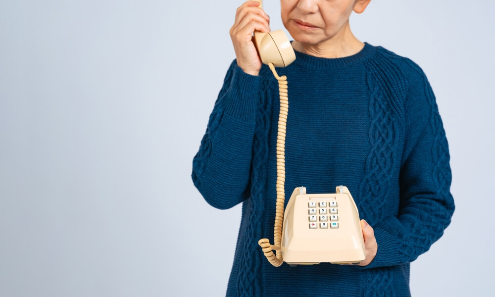A senior woman dialing phone numbers to never call.