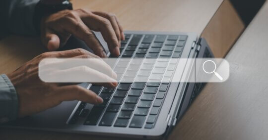 Conceptual image of a person typing on a keyboard with digital search and data icons representing how to search people on Amazon.