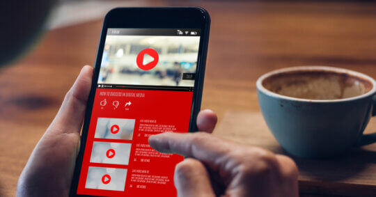 A person searching on YouTube while drinking coffee.