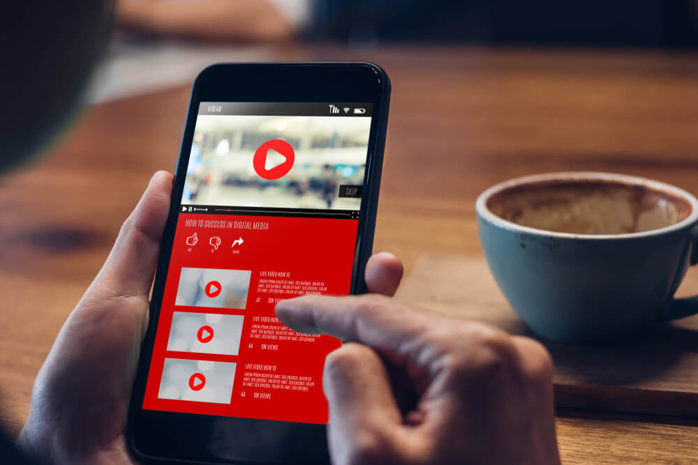 A person searching on YouTube while drinking coffee.