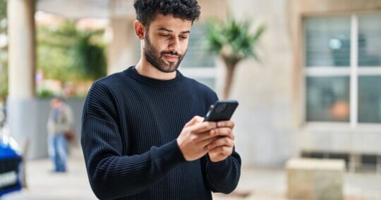 A man using his phone to run a VSCO people search.