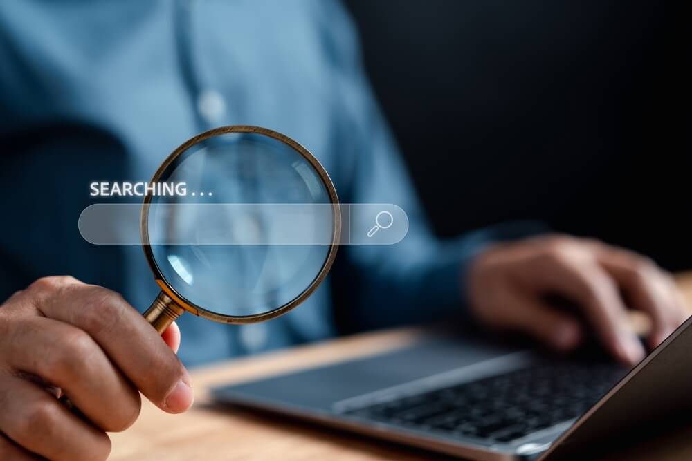 A man using his laptop to search people on OnlyFans.