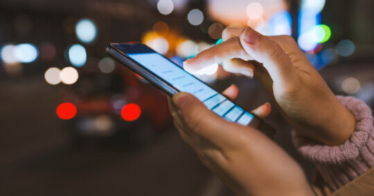 A person using their phone, checking if people can see what you search on Twitter.