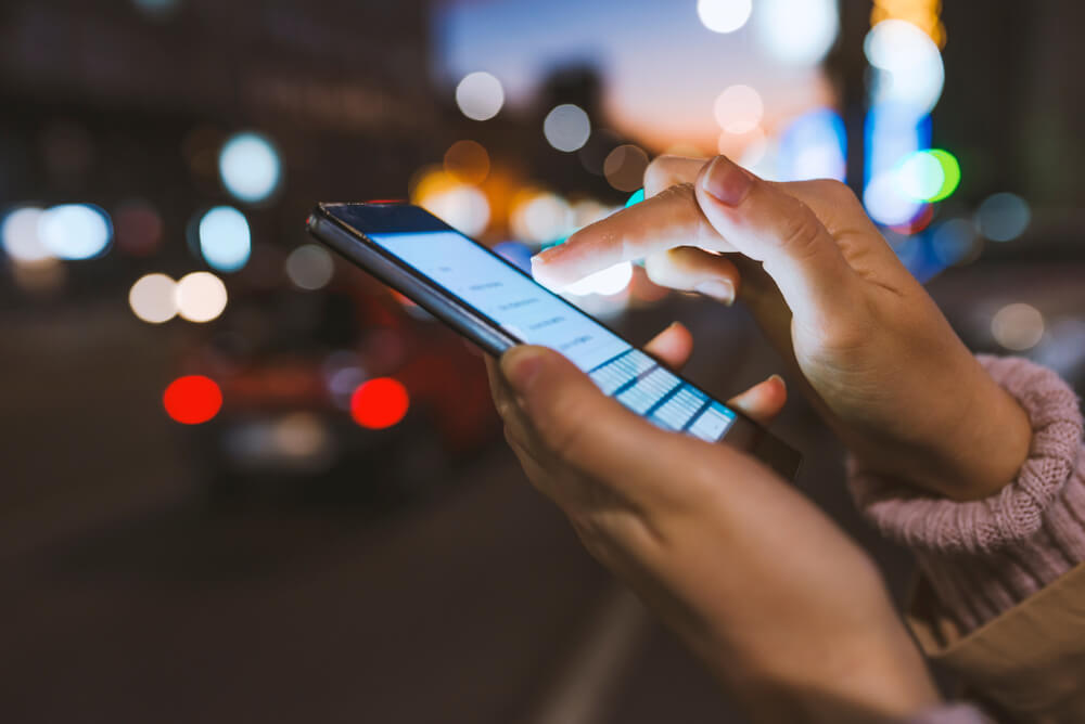 A person using their phone, checking if people can see what you search on Twitter.