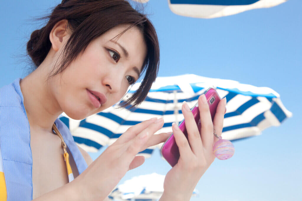 A woman using her phone to find people on Hinge.