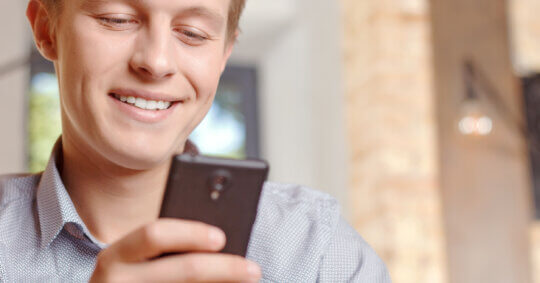 A man using his phone to see if he can search people on Hinge.