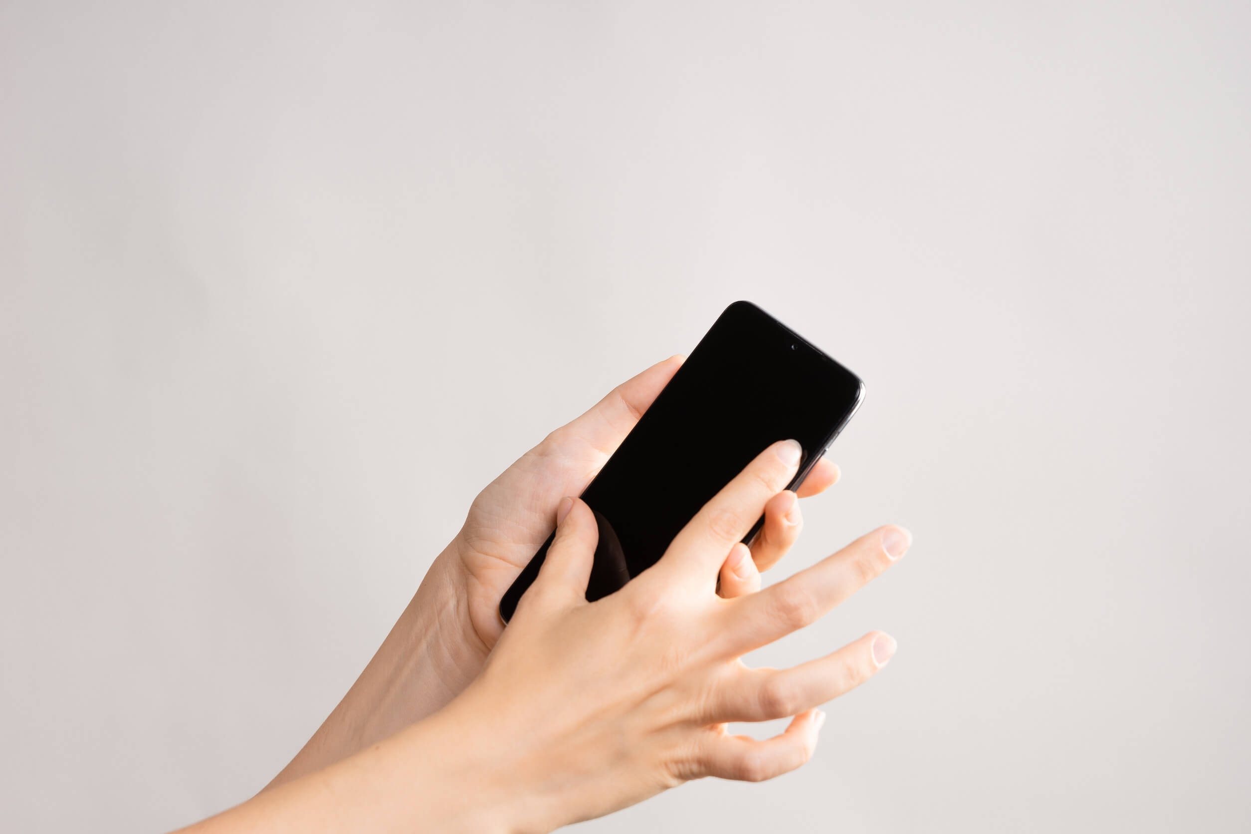 A person scrolling on her phone after learning how to do a Whatsapp phone number lookup.