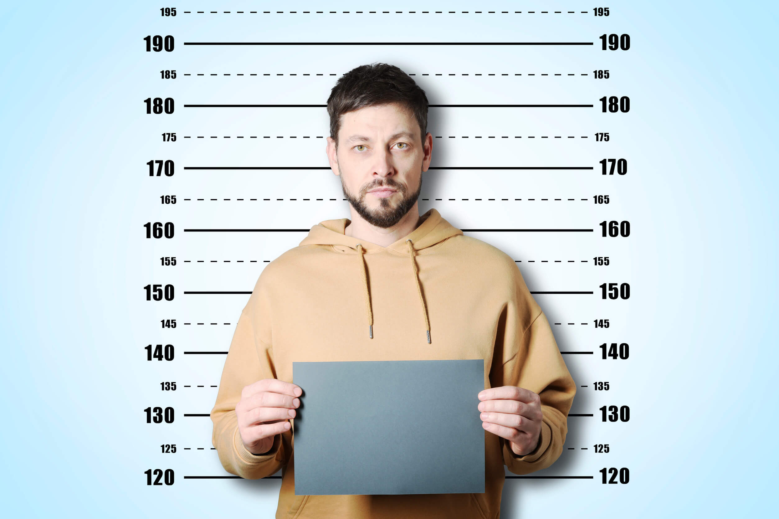 A man having his mugshot taken; he's wondering, "how long does a felony stay on your record?"