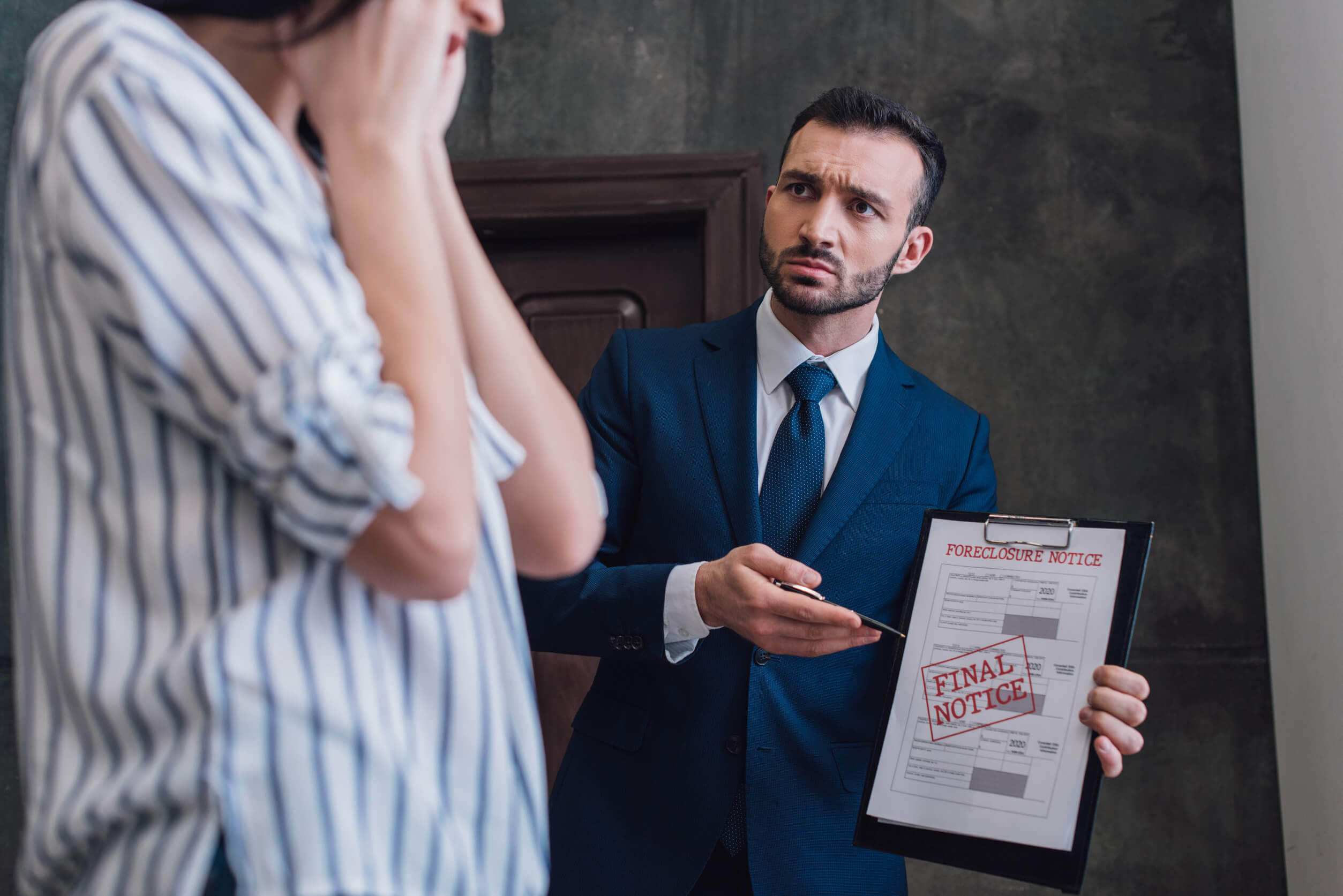 A landlord showing a tenant an eviction notice.