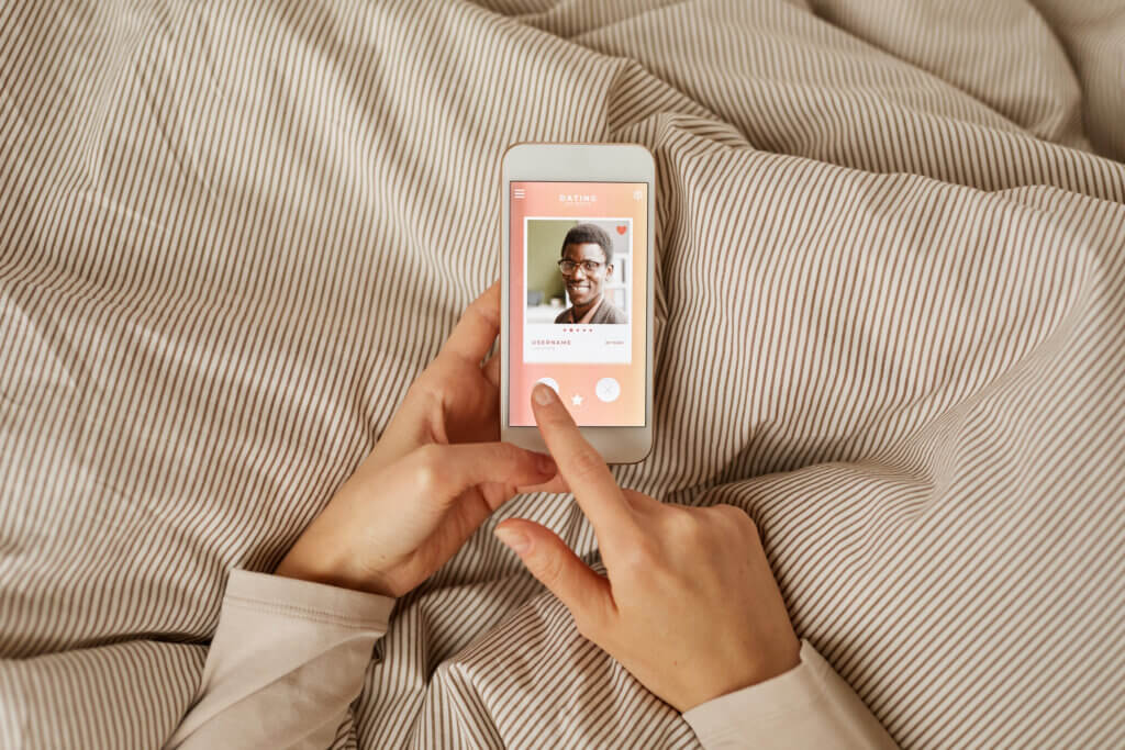 A woman using a dating site on their phone to find someone.