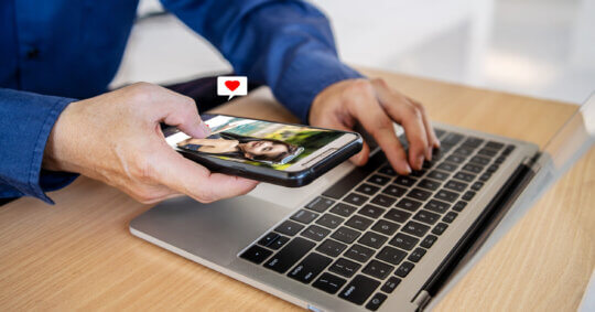 A man using a laptop to research how to find if someone is on a dating site.